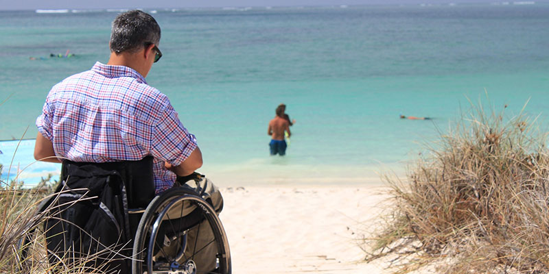 the man in a wheelchair looks at the sea
